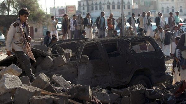 Yemenis stand at the site of a Saudi airstrike against Houthi rebels near Sanaa Airport on March 26, 2015, which killed at least 13 people. (photo credit: AFP/Mohammed Huwais)