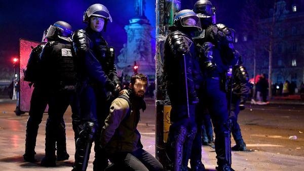 French riot police officers detain a demonstrator on Republic Square (AFP)