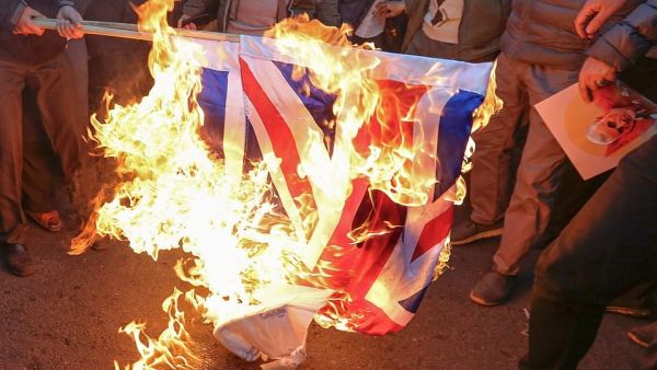 Iranian demonstrators set alight a Union Jack in front of the British embassy in Iran's capital Tehran today (AFP)