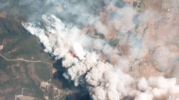 This handout satellite image, taken on December 31, 2019 and received from Planet Labs, Inc. on January 7, 2020, shows smoking rising into the air from bushfires near Lake Conjolia in the Australian state of New South Wales. (AFP)