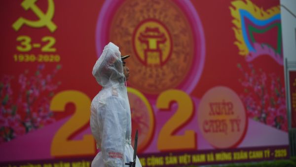A policeman stands in front of a poster marking the 90th anniversary of the Communist Party of Vietnam in Hanoi on February 3, 2020. Vietnam suspends mainland China flights over virus fears as it spread to two dozen nations and killed 259 people in China where it originated in the city of Wuhan. Nhac NGUYEN / AFP
