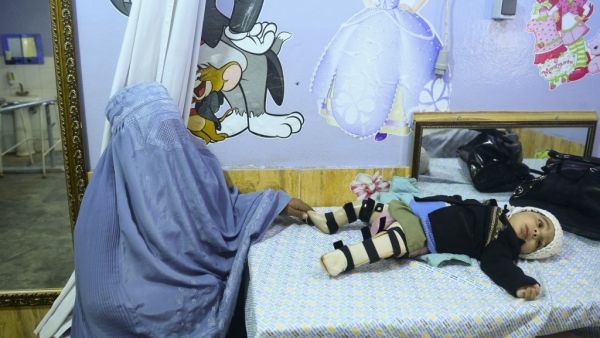 In this photo taken on February 2, 2020, a woman wearing a burqa sits next to her disable child at the International Committee of Red Cross (ICRC) hospital in Herat province. HOSHANG HASHIMI / AFP