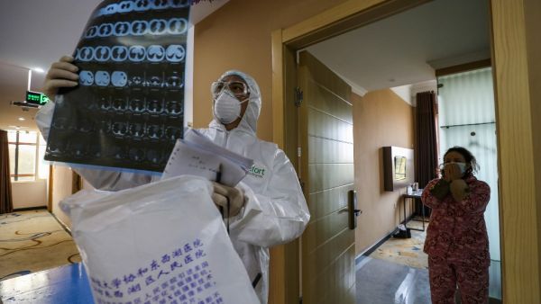 This photo taken on February 3, 2020 shows a doctor looking at a lung CT image while making his rounds at a ward of a quarantine zone in Wuhan, the epicentre of the new coronavirus outbreak, in China's central Hubei province. AFP