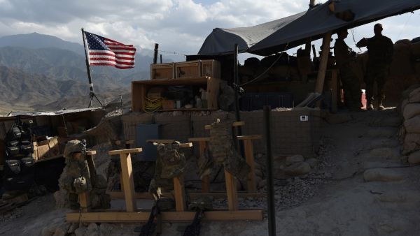 In this file photograph taken on July 7, 2018, US Army soldiers from NATO look on as U.S. flag flies at a checkpoint during a patrol against Islamic State militants at the Deh Bala district in the eastern province of Nangarhar Province. Two American troops were killed and six others wounded when an Afghan soldier armed with a machine gun opened fire, the US military confirmed on February 9. WAKIL KOHSAR / AFP