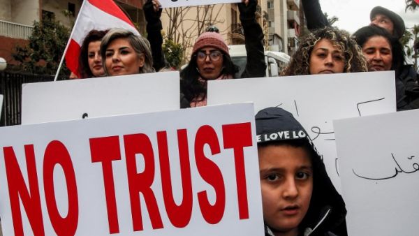 Anti-government demonstrators march with protest signs in the southern Lebanese city of Sidon on February 10, 2020, as they protest a day ahead of a parliamentary vote of confidence in the newly-formed government. Mahmoud ZAYYAT / AFP