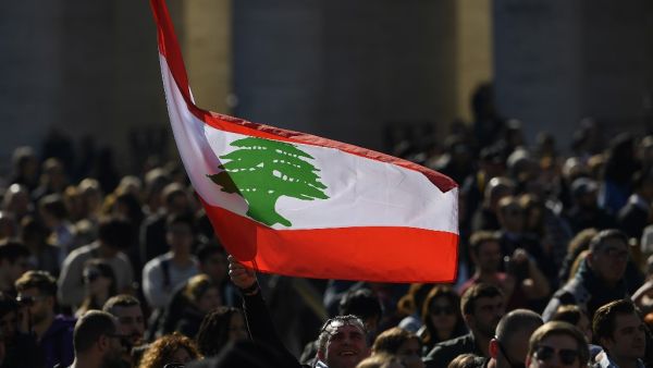 An attendee waves the flag of Lebanon during the Pope's weekly Angelus prayer on February 16, 2020 at St. Peter's Square in the Vatican. Filippo MONTEFORTE / AFP