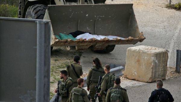 Israeli soldiers retrieve the body of a Palestinian in the village of Ras Karkar, near Ramallah in the occupied West Bank on February 17, 2020, reported to be the body of a man who wounded an Israeli soldier in a shooting attack ten days ago. ABBAS MOMANI / AFP