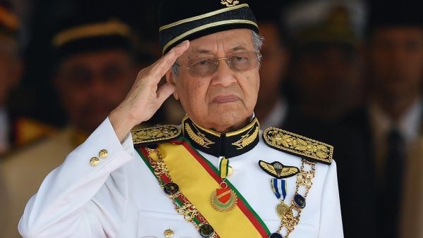 In this file photo taken on July 17, 2018, Malaysia's Prime Minister Mahathir Mohamad salutes the royal guard of honour during the opening ceremony of the parliament in Kuala Lumpur. Malaysian Prime Minister Mahathir Mohamad, at 94 the world's oldest leader, submitted his resignation to the king on February 24, 2020, his office said, after a bid by his political partners to bring down the government. Mohd RASFAN / AFP