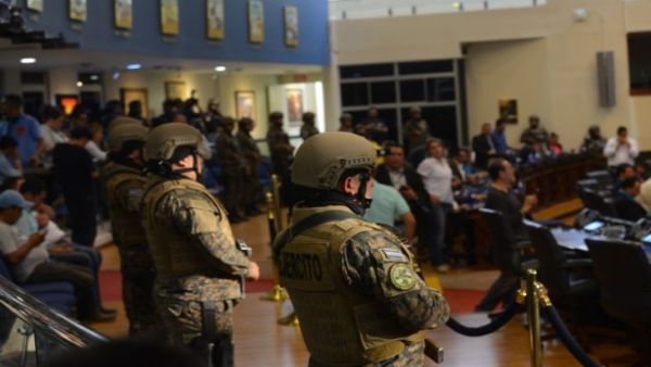 عسكريون مسلحون ببنادق ويرتدون سترات واقية من الرصاص يقتحمون مقر البرلمان