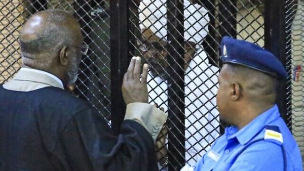 Sudan's deposed president Omar al-Bashir sits in a defendant's cage during his corruption trial at a court in Khartoum on December 14, 2019. (AFP)