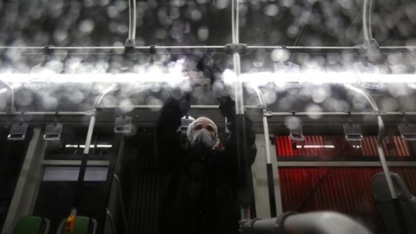 A Tehran Municipality worker cleans a bus to avoid the spread of the COVID-19 illness on February 26, 2020. Iran said Tuesday its coronavirus outbreak, the deadliest outside China, had claimed 15 lives and infected nearly 100 others -- including the country's deputy health minister. The Islamic republic's neighbours have imposed travel restrictions and strict quarantine measures after reporting their first cases in recent days, mostly in people with links to Iran. ATTA KENARE / AFP