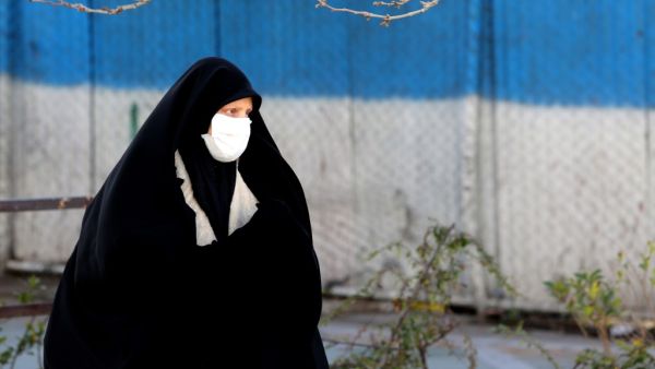 An Iranian woman wearing a protective mask crosses a road in Tehran on March 2, 2020, following the COVID-19 illness outbreak, which Iran says has claimed 66 lives out of 1,501 cases of infection in the Islamic republic since February. The novel coronavirus has sparked intense debate in Iran between ultra-conservative Shiite clerics and the government on how to most effectively tackle the deadliest outbreak of the disease outside China. ATTA KENARE / AFP