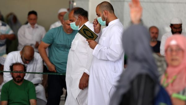 Worshippers, some of them wearing protective masks, take part in the Friday prayers in front of Mecca's Grand Mosque on March 6, 2020, a day after Saudi authorities emptied Islam's holiest site for sterilisation over fears of the new coronavirus COVID-19, an unprecedented move after the kingdom suspended the year-round umrah pilgrimage. Abdel Ghani BASHIR / AFP