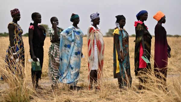 Women queue as they wait to receive food rations at a village in Ayod county, South Sudan, where World Food Programme (WFP) have just carried out a food drop of grain and supplementary aid on February 6, 2020. The villagers hear the distant roar of jet engines before a cargo plane makes a deafening pass over Mogok, dropping sacks of grain from its hold to the marooned dust bowl below. South Sudan is the last place on earth where food is airdropped, and in Mogok there was little other choice: without the ton