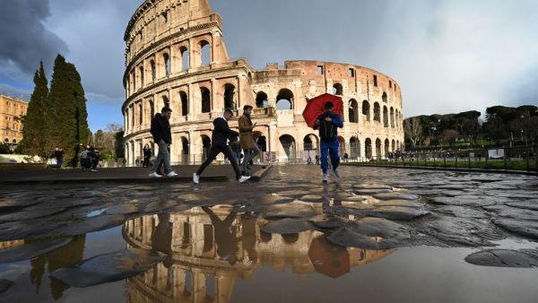 People pass by the Coliseum in Rome on March 7, 2020 amid fear of Covid-19 epidemic. Italy on March 6, 2020 reported 49 more deaths from the new coronavirus, the highest single-day toll to date, bringing the total number of fatalities over the past two weeks to 197. Alberto PIZZOLI / AFP