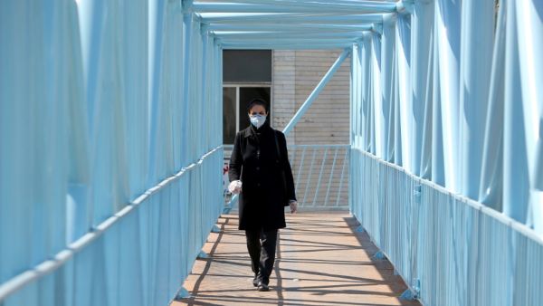 An Iranian pedestrian walks while wearing a protective mask in Tehran on March 10, 2020 amid the spread of coronavirus in the country. Iran today reported 54 new deaths from the novel coronavirus in the past 24 hours, the highest single-day toll since the start of the country's outbreak.  ATTA KENARE / AFP