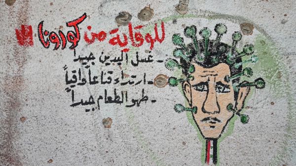 A graffiti portraying President Bashar al-Assad as the coronavirus is seen on the wall of a destroyed school in Binnish town in Syria’s northwestern Idlib province near the Turkish border, on March 10, 2020. AFP/File