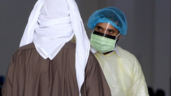 Kuwaiti healthy ministry workers scan expatriates living in Kuwait who returned from Egypt, Syria and Lebanon, as they arrive to a specified place to be tested for coronavirus in Kuwait City on March 12, 2020. YASSER AL-ZAYYAT / AFP