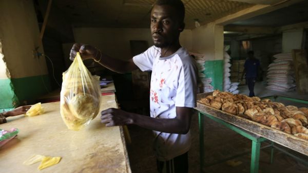 A Sudanese baker sells bread at a bakery in Omdourman on March 11, 2020. Sudan's economy has sunk into a deep crisis since the fall of longtime autocrat Omar al-Bashir almost a year ago, risking collapse and social unrest in a country in political transition. Anti-government protests erupted in Sudan in late 2018 against a government decision to triple bread prices. Bashir's ouster last April led to months of talks, also against a backdrop of mass protests, that eventually produced a transitional government