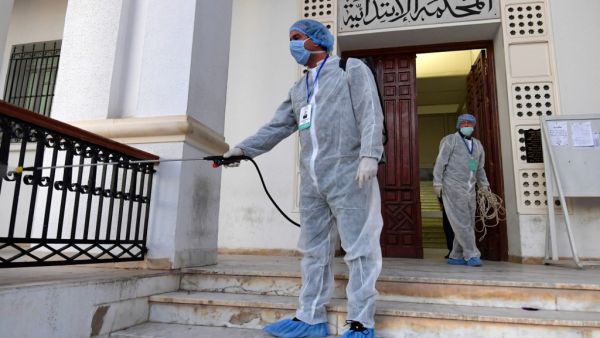 Tunisian public health workers disinfect the entrance to the Ariana tribunal near the capital Tunis, to prevent the spread of the coronavirus COVID-19, on March 12, 2020. FETHI BELAID / AFP