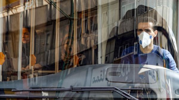 A bus driver wearing a protective mask as a precaution against COVID-19 coronavirus disease operates a bus in Iran's capital Tehran on March 15, 2020. STRINGER / AFP