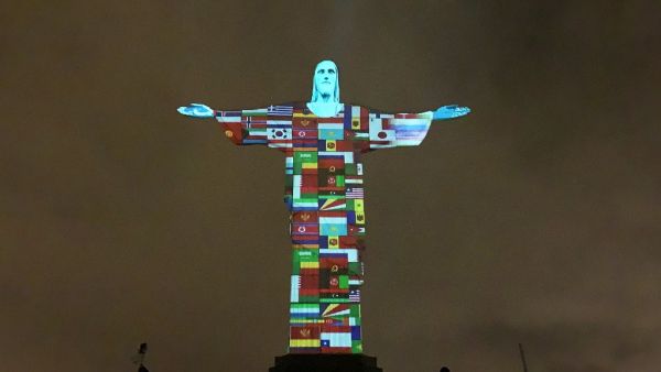 Flags of the countries affected by the spread of the new coronavirus, COVID-19, are prjected on the statue of the Christ Redemeer atop Corcovado hill in Rio de Janeiro, Brazil, on March 18, 2020. AFP