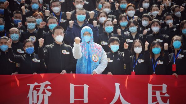 Members of a medical assistance team from Jiangsu province chant slogans at a ceremony marking their departure after helping with the COVID-19 coronavirus recovery effort, in Wuhan, in China's central Hubei province on March 19, 2020. Medical teams from across China began leaving Wuhan this week after the number of new coronavirus infections dropped. China on March 19 reported no new domestic cases of the coronavirus for the first time since it started recording them in January, but recorded a spike in infe