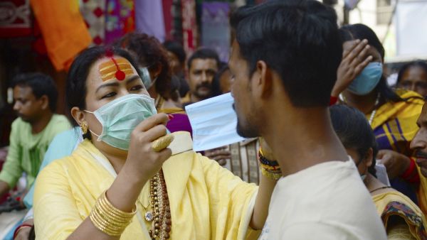 A member of the transgender community distributes free facemask amid concerns over the spead of the COVID-19 coronavirus, at a market area in Allahabad on March 19, 2020. SANJAY KANOJIA / AFP