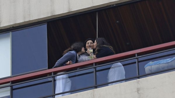Young girls kiss their mother who just received a rose delivered to her via a drone on Mother's day, in the Lebanese coastal city of Jounieh, north of the capital Beirut on March 21, 2020, as people remain indoors in an effort to limit the spread of the novel coronavirus. In a quiet Lebanese town under lockdown over the novel coronavirus, a drone buzzed towards a balcony on Saturday to deliver a red rose to a mother grinning in surprise. The COVID-19 pandemic may have put a damper on Mother's Day this year,