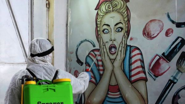 A volunteer disinfects a shop in Baghdad's Bayaa neighbourhood on March 21, 2020 as a preventive measure against the spread of the coronavirus COVID-19. AHMAD AL-RUBAYE / AFP