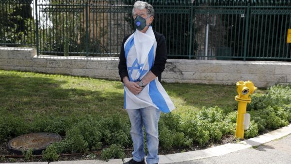 An Israeli man wearing a protective masks against COVID-19 coronavirus disease attends a protest outside the Knesset (parliament) in Jerusalem on March 23, 2020 against the recent decision by Knesset speaker to shut it down, and against what they describe as "damaged to Israel's democracy". Menahem KAHANA / AFP