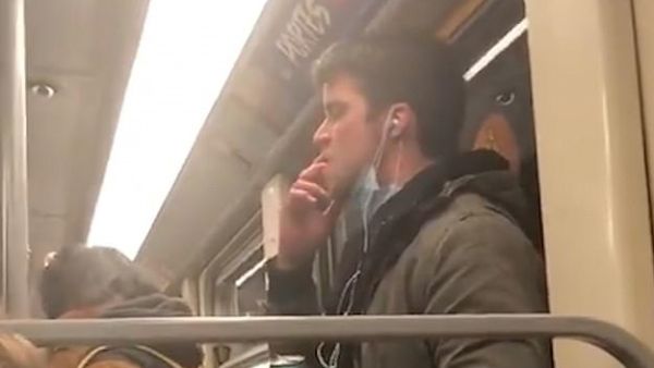 He then lifts his right hand up to his mouth and licks his fingers while eyeing the vertical Brussels subway rail in front of him  (Twitter)