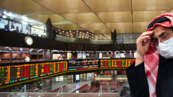 A Kuwaiti trader wearing a protective mask follows the market at the Boursa Kuwait stock exchange in Kuwait City, March 1, 2020. (Yasser al-Zayyat/AFP)