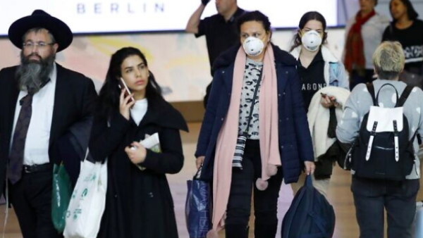 Israeli Passengers wearing protective masks in the arrivals halls at Ben Gurion International Airport near Tel Aviv on March 10, 2020. (Jack Guez/AFP)