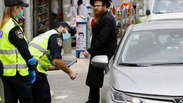Israeli police talk to a driver at a checkpoint in Bnei Brak, a predominantly ultra-Orthodox city east of Tel Aviv, on March 31, 2020, as part of measures to curb the spread of the coronavirus. (Jack Guez/AFP)