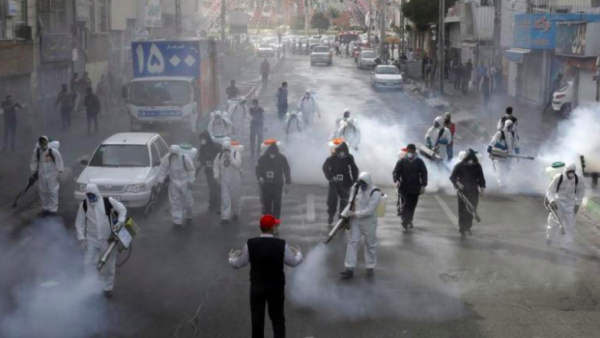 Iranian firefighters disinfect streets in a bid to halt the spread of coronavirus in Tehran on March 13. (AFP)