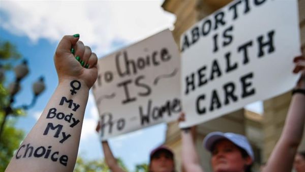 A protester holds up her arm with 'My Body My Choice' written on it during a protest against recently passed abortion ban bills at the Georgia State Capitol building [Elijah Nouvelage/Getty Images/AFP] 