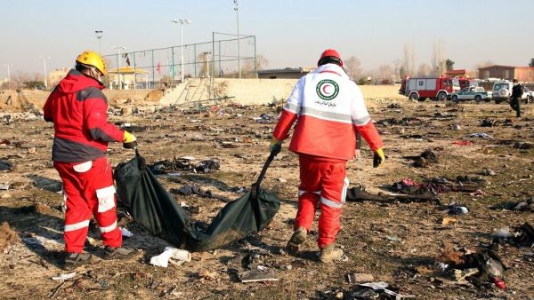 Rescue teams recover a body after a Ukrainian plane carrying 176 passengers crashed near Imam Khomeini airport in the Iranian capital Tehran on January 8, 2020, killing everyone on board. (AFP)