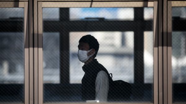A man wearing a face mask amid concerns over the spread of the COVID-19 coronavirus walks in Shinagawa station in Tokyo on April 6, 2020. Behrouz MEHRI / AFP