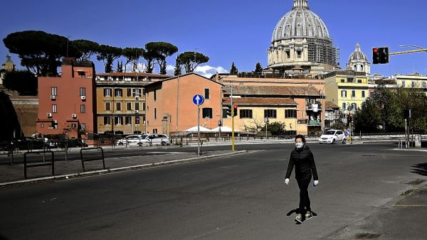 A woman walks with St Peter's Basilica in the background in Rome on April 6, 2020, during the country's lockdown aimed at curbing the spread of the COVID-19 infection, caused by the novel coronavirus. Filippo MONTEFORTE / AFP