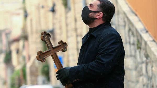 A Christian pilgrim wearing protective gear amid the COVID-19 outbreak, prays at the first station while making his way alone in the Procession of the Way of the Cross along the Via Dolorosa, to mark Good Friday in Jerusalem on April 10, 2020. AFP/File