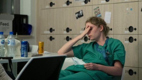 Mathilde Dumont, a 27-year-old nurse, reacts to tiredness early on April 11, 2020, during her night shift in the intensive care unit exclusively for COVID-19 patients at the Ixelles Hospital in Brussels, amid the COVID-19 pandemic, caused by the novel coronavirus. Aris Oikonomou / AFP