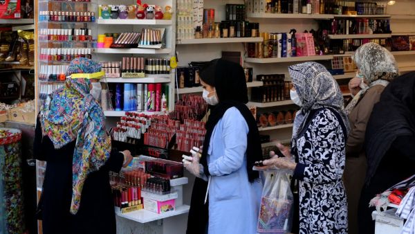 Iranians wearing protective gear amid the COVID-19 pandemic, queue to pay at a shop outside of the Grand Bazaar market in the capital Tehran, on April 18, 2020. Iran allowed some shuttered Tehran businesses to reopen on April 18, despite the Middle East's deadliest coronavirus outbreak, as many faced a bitter choice between risking infection and economic ruin. ATTA KENARE / AFP