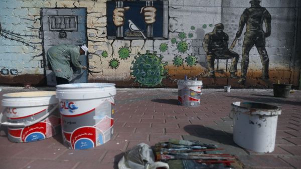 A Palestinian artist paints a mural in a show of support for Palestinian prisoners held in Israeli jails amid the COVID-19 pandemic, in Gaza City on April 20, 2020. Mohammed ABED / AFP