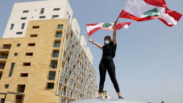 An anti-government protester stands of the top of a car during a convoy protest in the Lebanese capital Beirut on April 22, 2020, amid an economic crisis exacerbated by the coronavirus pandemic. ANWAR AMRO / AFP