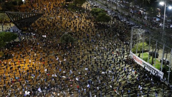Israelis wearing protective masks and dressed mainly in black, take part in a demonstration on April 25, 2020, in Rabin Square in the coastal city of Tel Aviv, to protest what they consider threats to Israeli democracy, against the backdrop of negotiations between Prime Minister Benjamin Netanyahu and his ex-rival Benny Gantz. The protesters stood two meters apart from each other, thereby respecting the social distancing measures in force to fight the COVID-19 pandemic. JACK GUEZ / AFP
