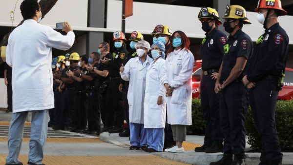 Members of the Glendale police and fire departments pose with healthcare workers as they pay tribute to the healthcare workers during a shift change at Glendale Memorial Hospital amid the coronavirus pandemic on April 16, 2020 in Glendale, California. AFP/File