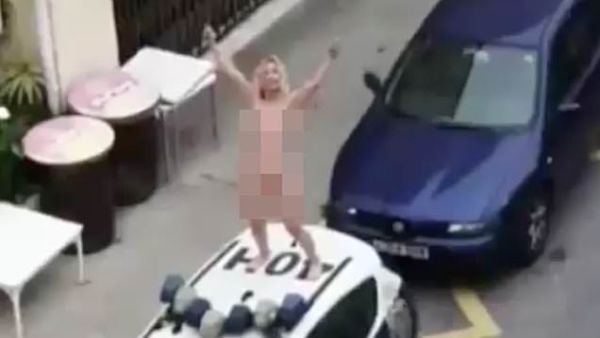 Woman strips and leaps on top of a police car  (Twitter)