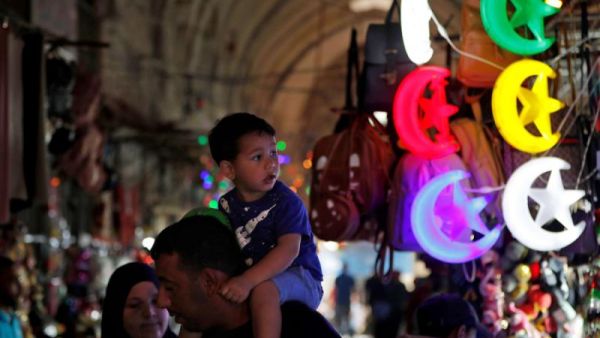 Palestinians walk past shops decorated ahead of the Muslim holy fasting month of Ramadan, in Jerusalem's old city, May 2. (AFP)