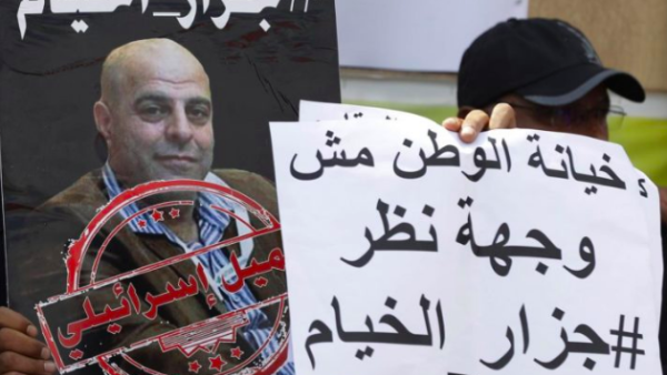 A protester in the southern Lebanese village of Khiam holds a sign that reads, "Betraying the country is not a point of view", September 15, 2019. (AFP/File Photo)